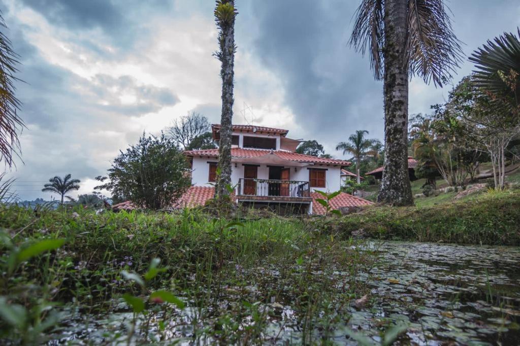 una casa en la cima de una colina con palmeras en Finca Hotel Santa Bàrbara, en Miraflores