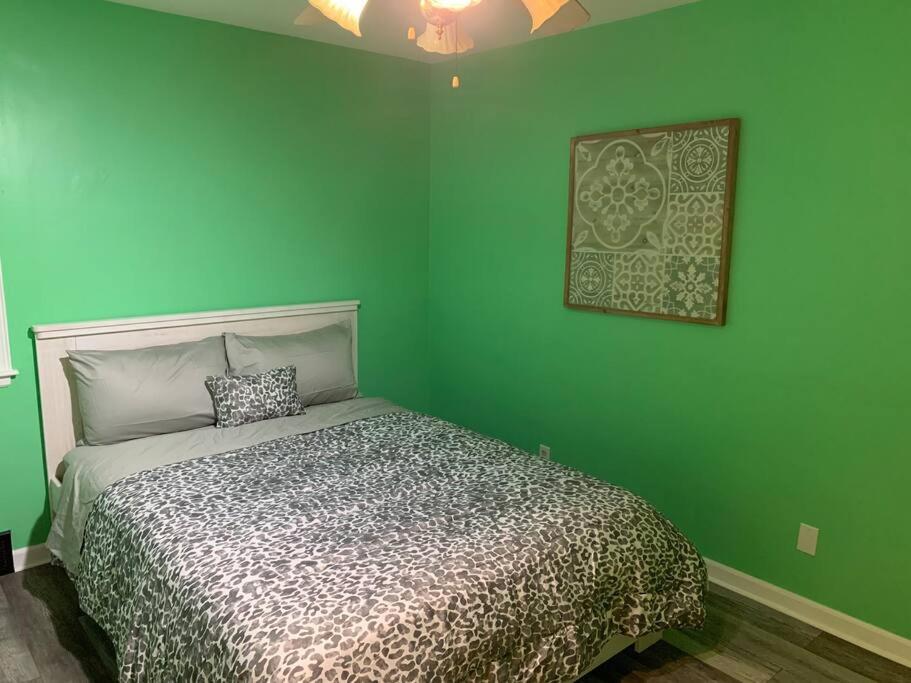 a bedroom with green walls and a bed in it at Remodeled House Minutes to Falls Attractions in Niagara Falls