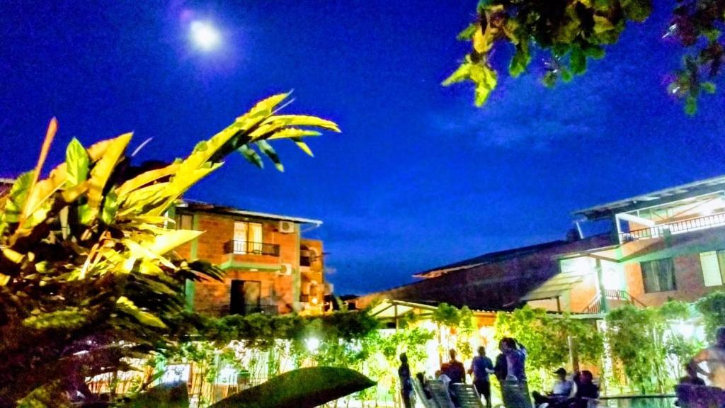 un grupo de personas de pie fuera de un edificio por la noche en Hotel Bahía Yubarta, en Bahía Solano