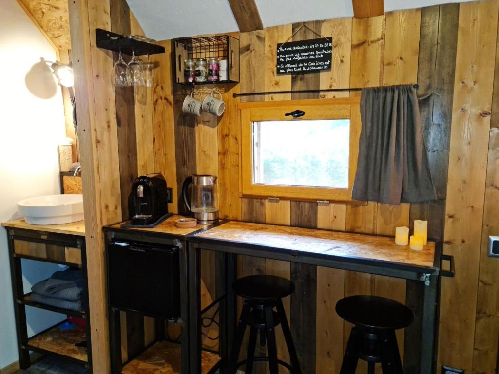 a kitchen with a bar in a tiny house at Cab&#39;ânes du Pibeste in Ségus