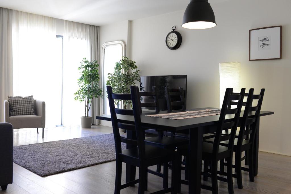 a dining room with a black table and chairs at Lux Apartment with Pool and Garage in Lisbon