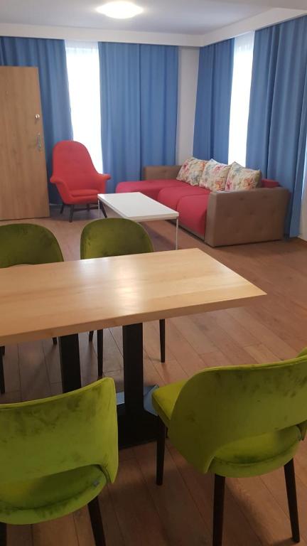 Zimmer mit einem Tisch, Stühlen und einem Sofa in der Unterkunft Apartament 1 Budiu in Târgu Mureș