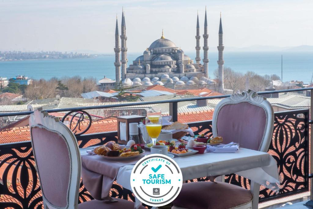 a table with food on a balcony with a view of a mosque at Rast Hotel Sultanahmet in Istanbul