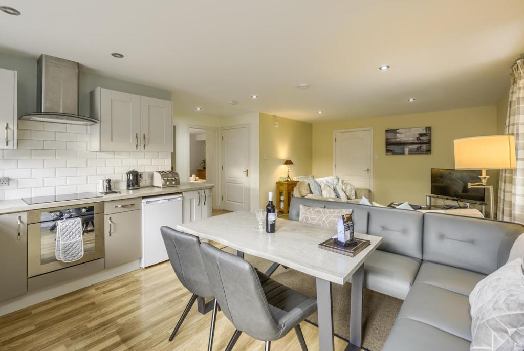 a kitchen and living room with a table and chairs at Apartment 20 Inchmarlo in Banchory