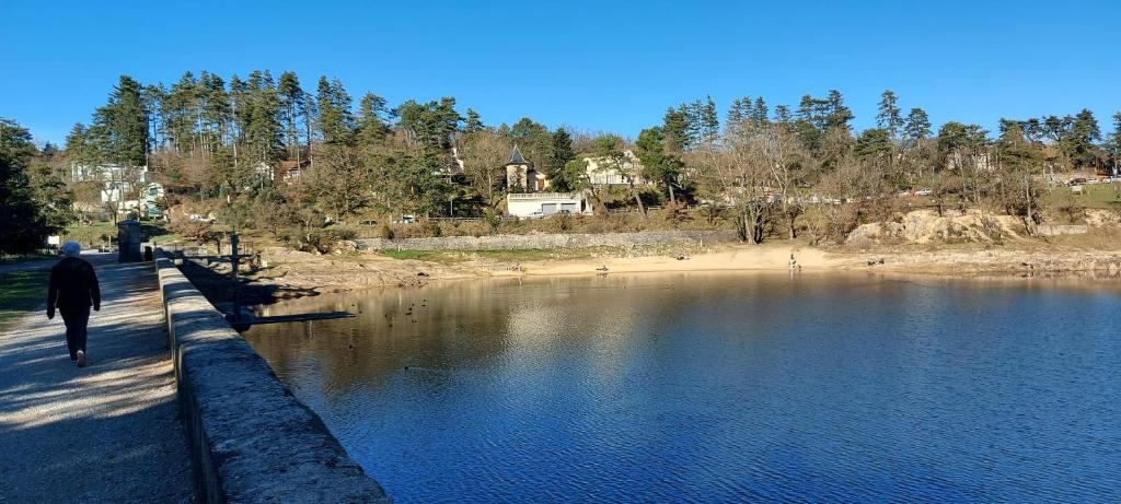 T2 le Lac de st-ferréol في ريفيل: شخص يمشي على رصيف بجانب تجمع الماء