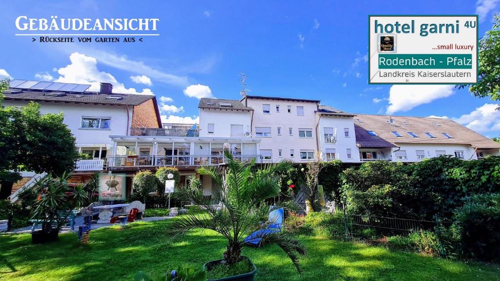 a group of buildings in a yard with a palm tree at Appartements 4U Rodenbach in Rodenbach