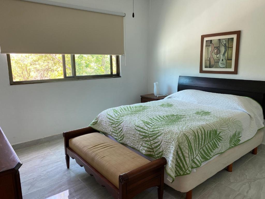 um quarto com uma cama grande e uma janela em Closetoairport em Cancún