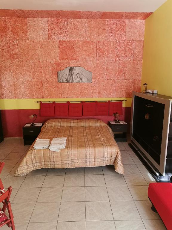 Un dormitorio con una cama con cabecero rojo. en GIGIOTTO, en Siracusa