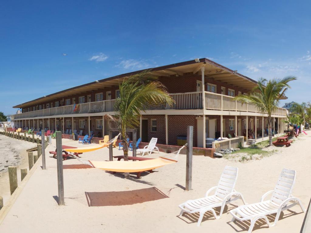 een gebouw op het strand met stoelen en surfplanken bij Oceanic Motel in Ocean City