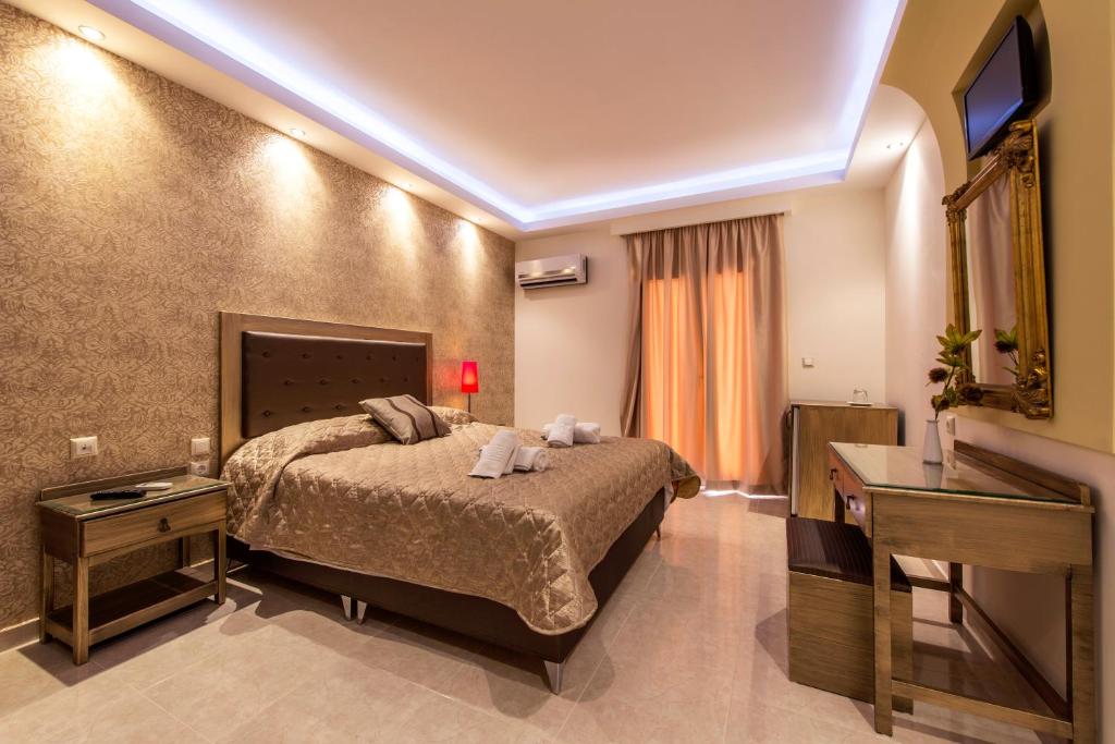 pokój hotelowy z łóżkiem i telewizorem w obiekcie Pirofani w mieście Leukada (miasto)