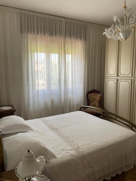 a bedroom with a white bed and a window at A casa di Zia Maria in Fuscaldo