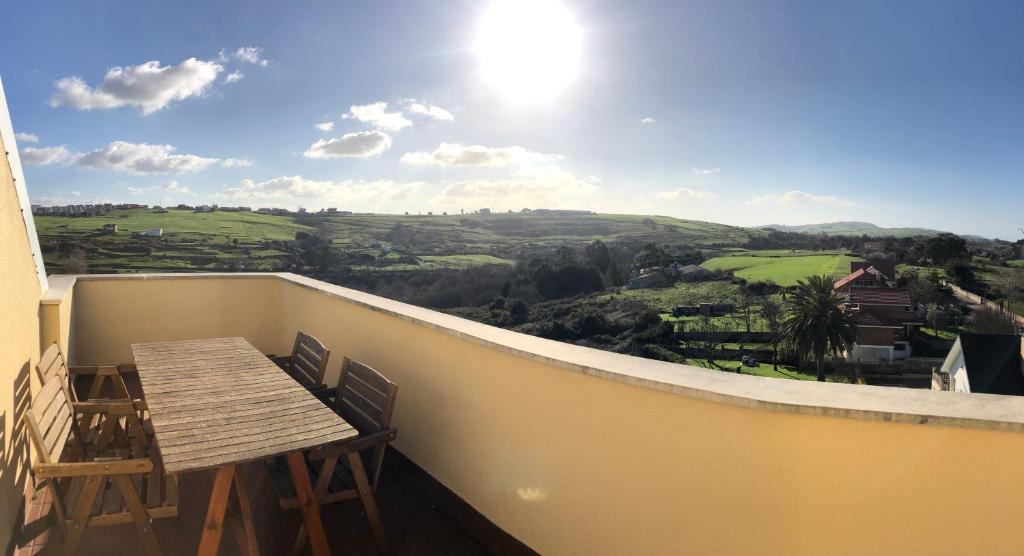 balcón con mesa y vistas al valle en En Busca del Viento del Norte Suances en Suances