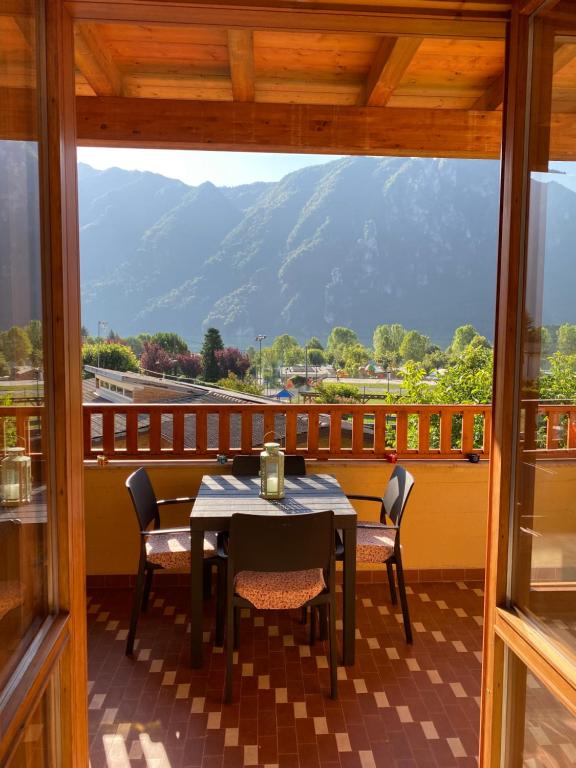 a table and chairs on a balcony with a view of a mountain at Casa Giulia - Appartamento Anfo in Anfo