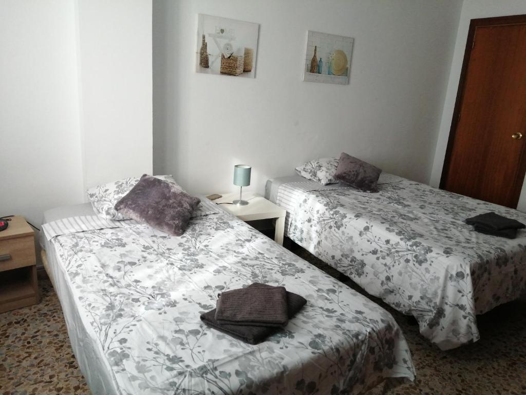 ネルハにあるNERJA 3aのベッド2台、テーブル(ランプ付)が備わる客室です。