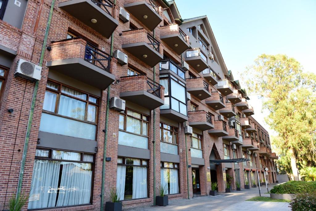 an apartment building with balconies on a street at Green Sea Apart Hotel in Pinamar