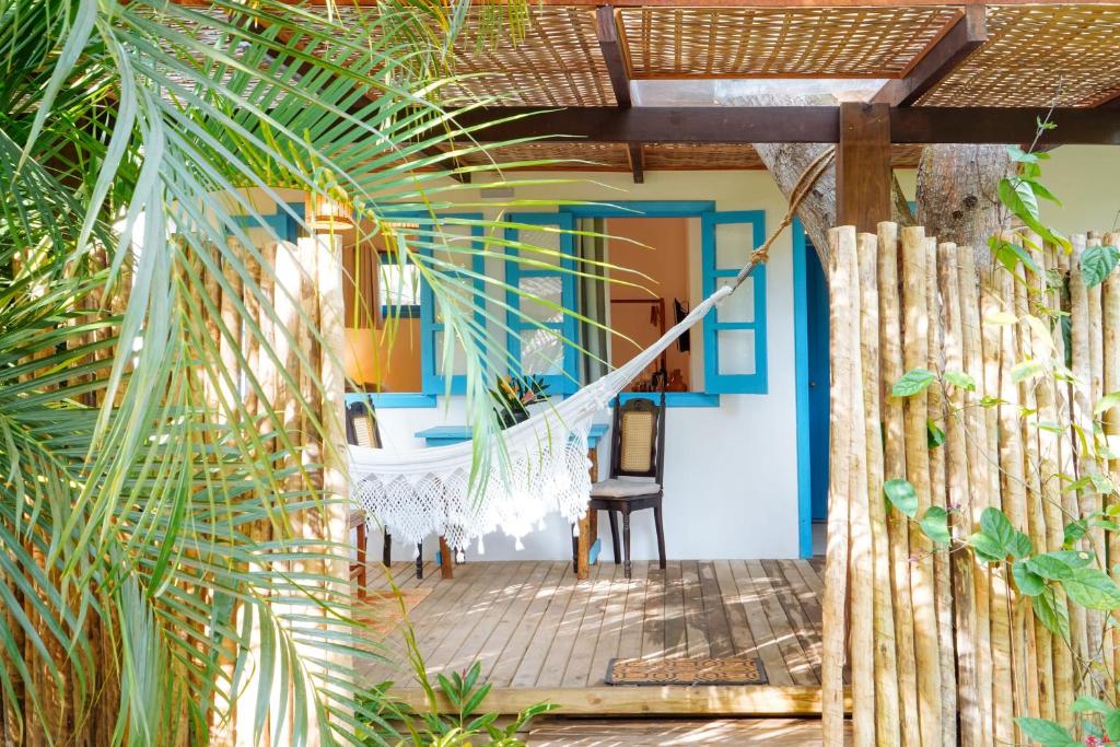 une terrasse couverte d'une maison avec une porte bleue dans l'établissement Aqualtune Pousada, à Barra Grande