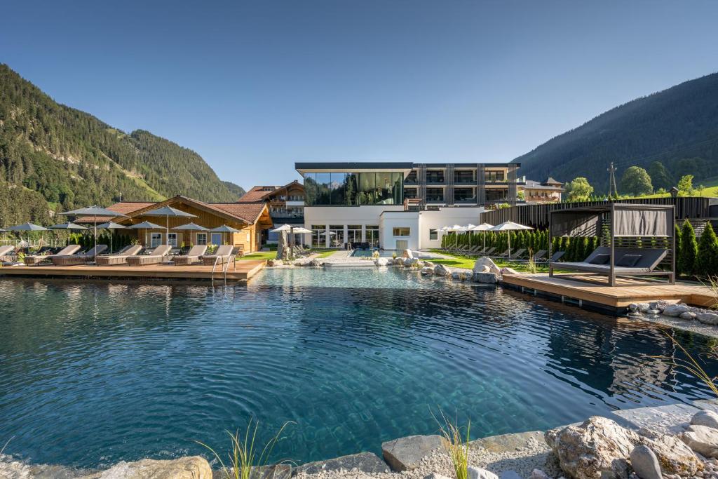 un complexe avec une piscine dans les montagnes dans l'établissement Alpin Life Resort Lürzerhof, à Untertauern