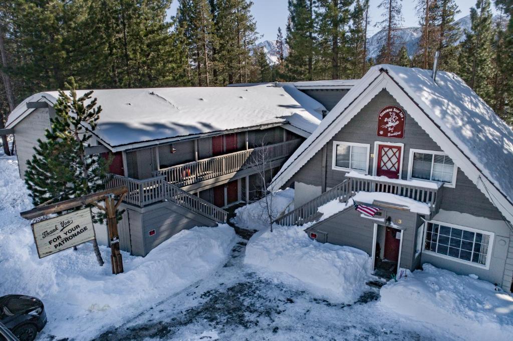 una casa coperta di neve con un cartello davanti di Cinnamon Bear Inn a Mammoth Lakes