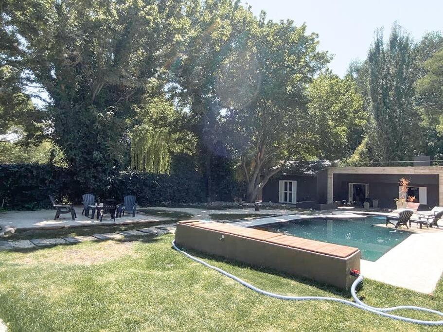a backyard with a swimming pool with a hose at Casa en el Bosque con piscina in Ciudad Lujan de Cuyo
