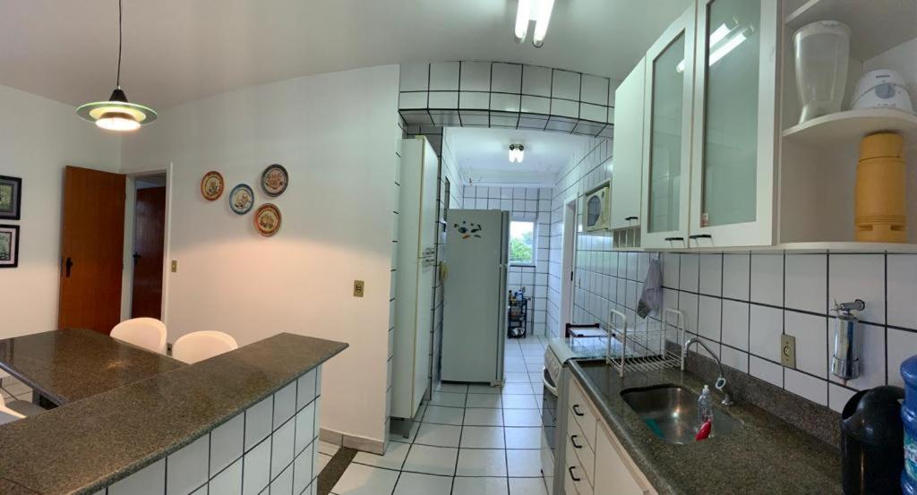 una cucina con lavandino e piano di lavoro di Apartamento Pé na Areia e águas tranquilas no centro de Guarapari a Guarapari