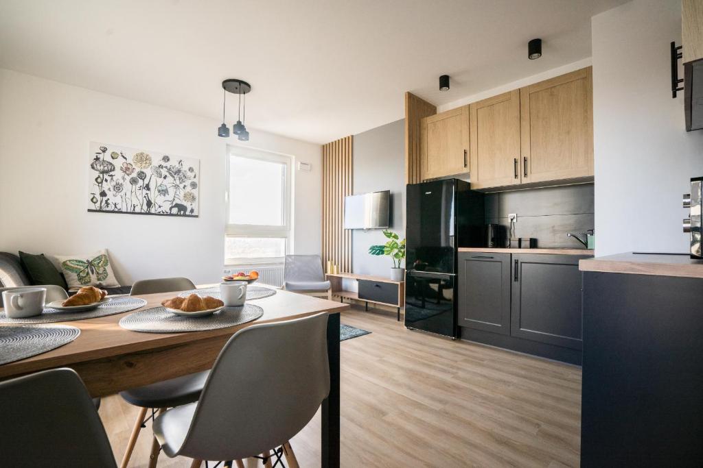 a kitchen with a stove a refrigerator and a microwave at Bizapartments - Modern Flats in Warsaw