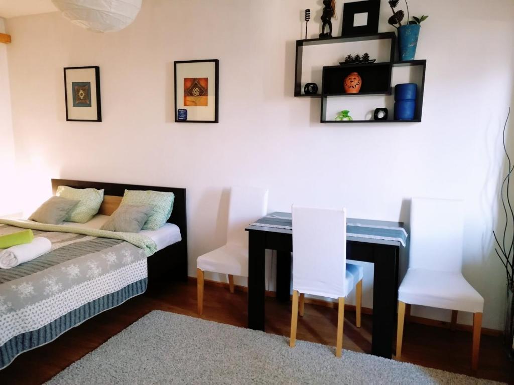Schlafzimmer mit einem Bett, einem Schreibtisch und Stühlen in der Unterkunft Nexus Happy in Miercurea Ciuc