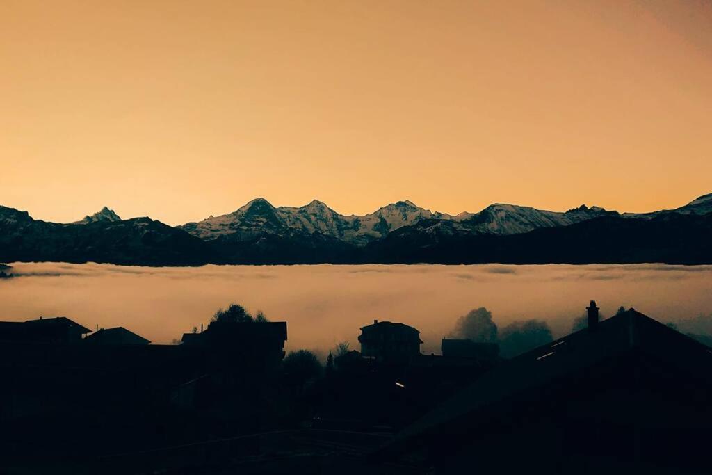 a view of a mountain range with a fog in the foreground at Känzeli - Ferienwohnung mit Traumaussicht in Beatenberg