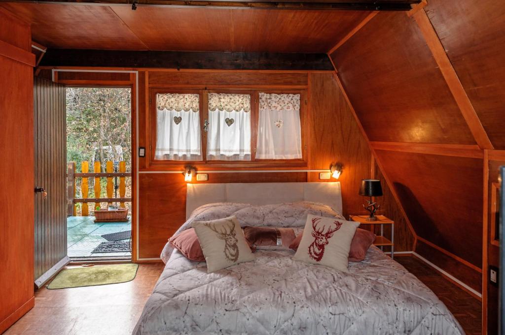 een slaapkamer met een groot bed en een houten plafond bij La casa dei funghi in Pedara