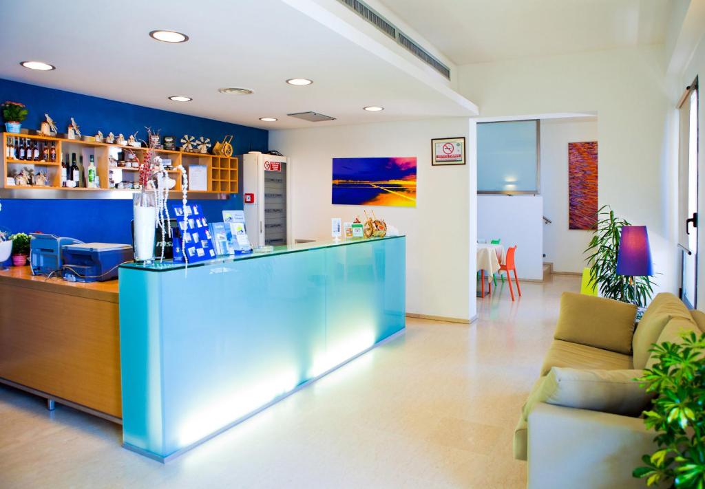 un bar en una habitación con una pared azul en Le Saline Hotel, en Paceco