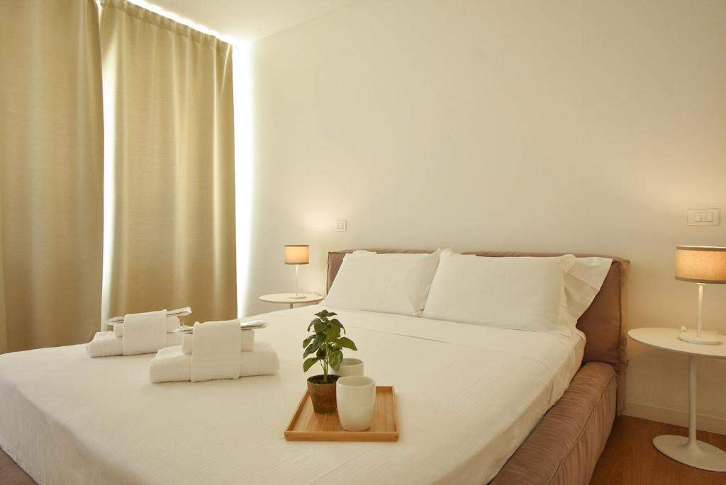 a bedroom with a white bed with a plant on it at Luxury Battisti in Padova