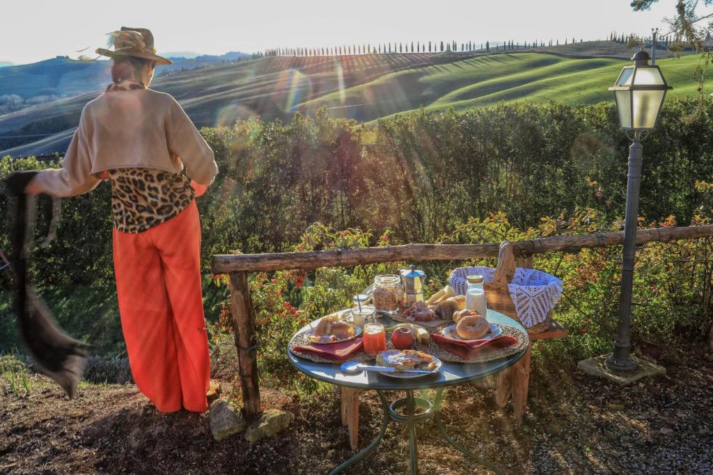 Agriturismo Bombina في Montisi: رجل واقف بجانب طاولة عليها طعام