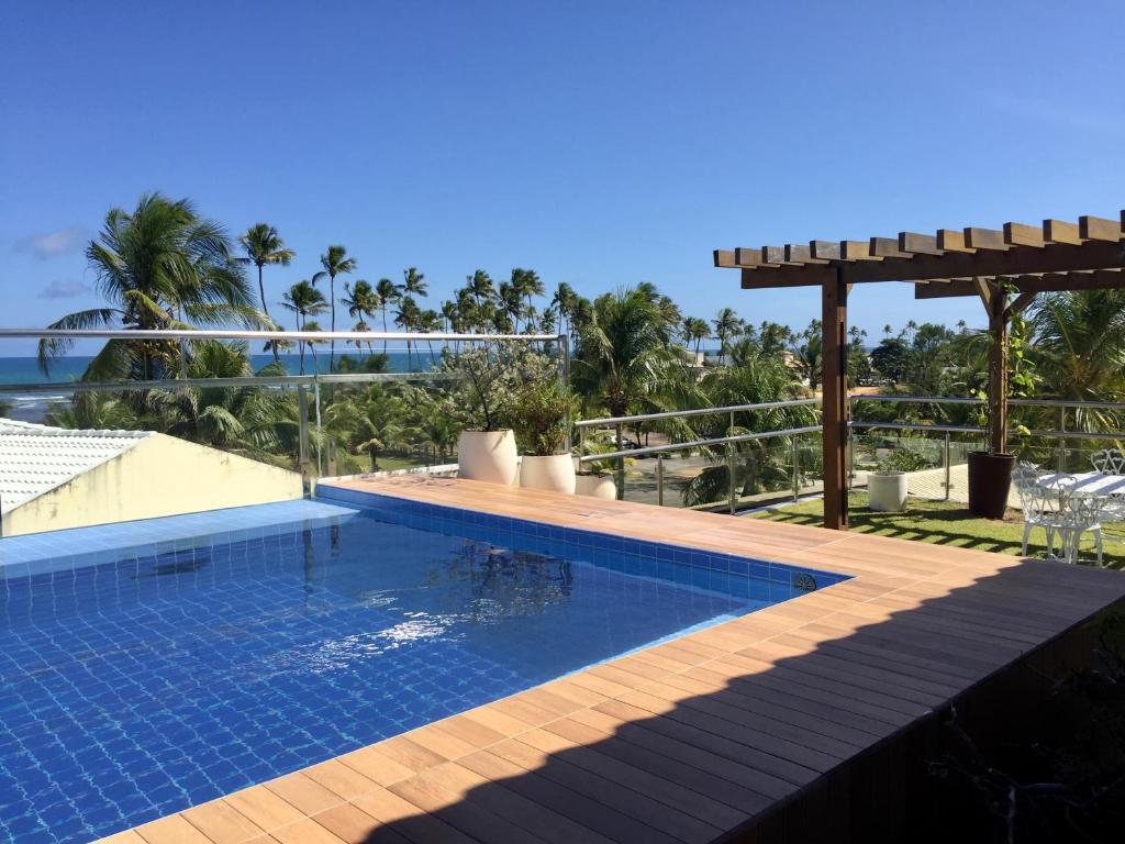 uma piscina com vista para o oceano em Casa Estrela do Mar Guarajuba em Guarajuba