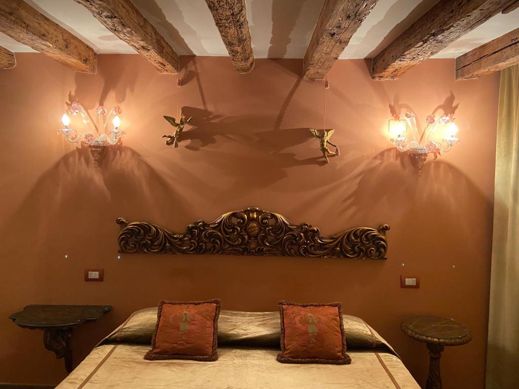 a bedroom with a bed with two lights on the wall at CA' DE' KOCAI in Venice