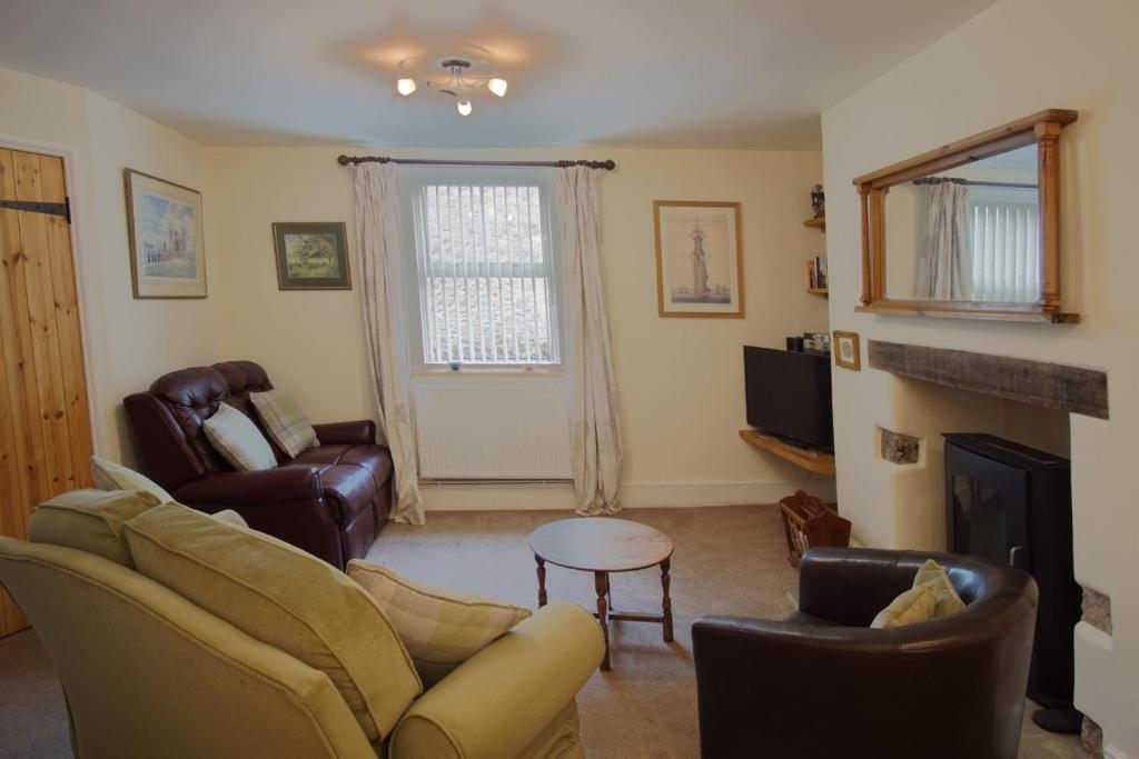 a living room with a couch and chairs and a fireplace at Tannery Mews in Chudleigh