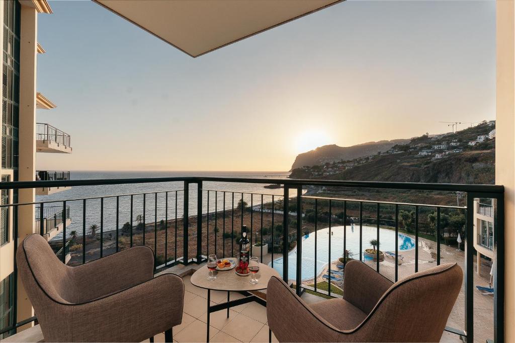 a balcony with chairs and a view of the ocean at Infinity pool & Amazing Sunset Ocean View in Funchal