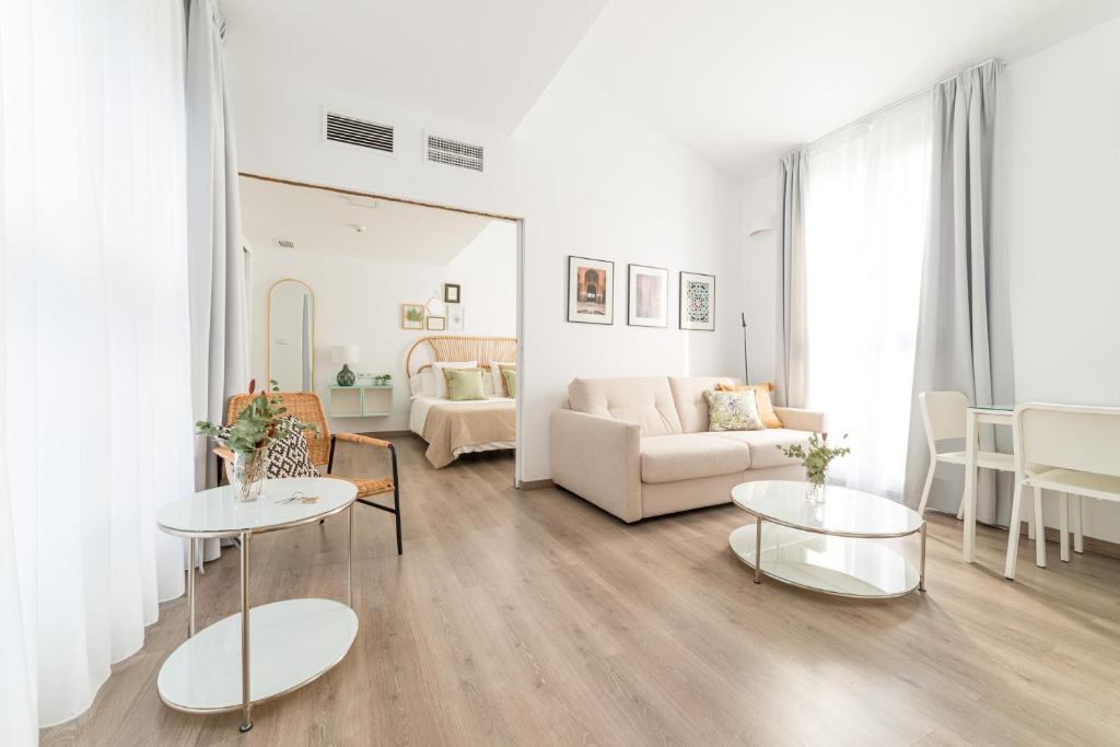 sala de estar con 2 mesas y sofá en Apartamentos con encanto en el centro de Granada, en Granada