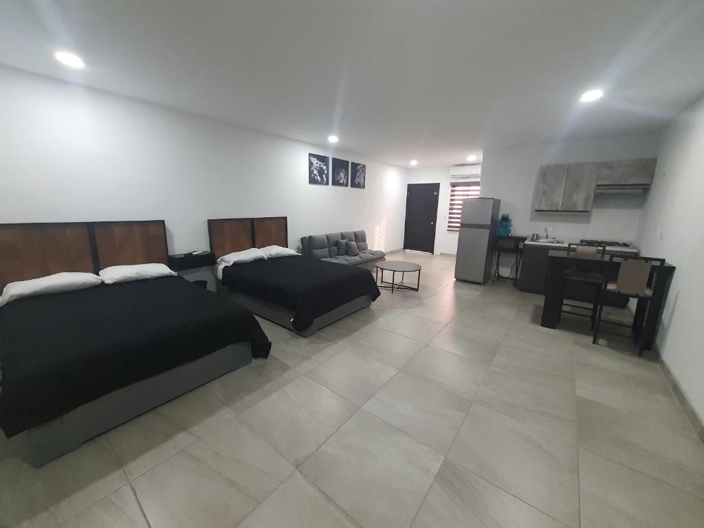 a living room with two beds and a kitchen at Life in Puerto Peñasco