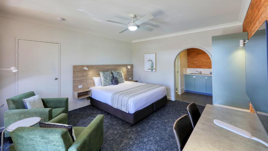 Habitación de hotel con cama y sillas en Hamilton Henry Parkes Motor Inn, en Parkes