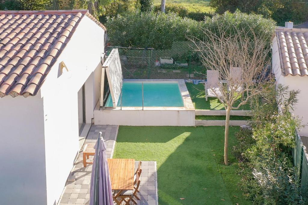 een uitzicht op een achtertuin met een zwembad bij Bienêtre et détente pour cette maison avec spa au calme in La Roquette-sur-Siagne