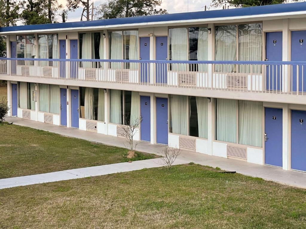 een appartementencomplex met blauwe deuren en een stoep bij Motel 6 Marianna, FL in Marianna