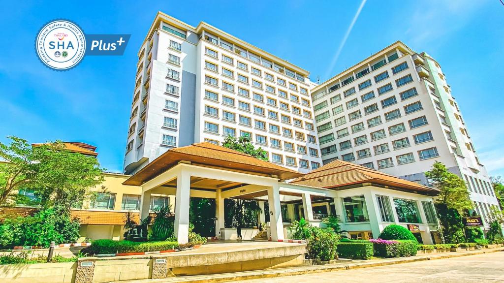 un hôtel situé en face d'un grand bâtiment dans l'établissement K Park Grand Hotel SHA PLUS certified, à Surat Thani