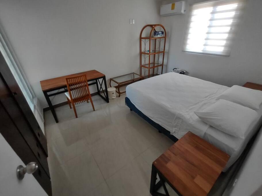 a bedroom with a bed and a table and a chair at Un pedacito de arena en Cancún in Cancún