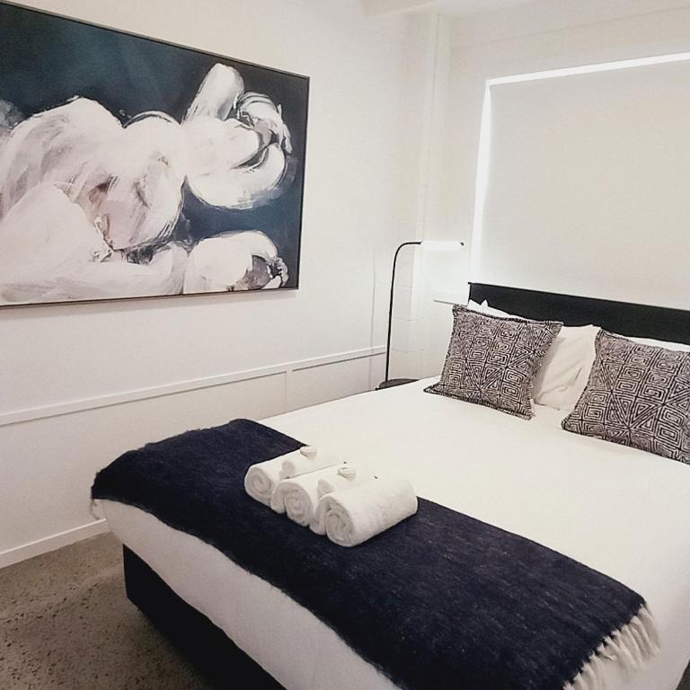 a bedroom with a bed with two folded towels on it at Harbourside 29B ~ Boat Parking in Coromandel Town