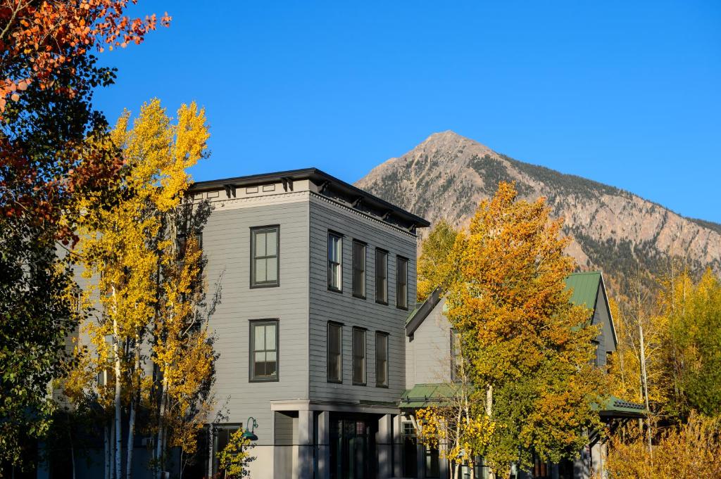an old house with a mountain in the background at Crested Butte Hostel in Crested Butte