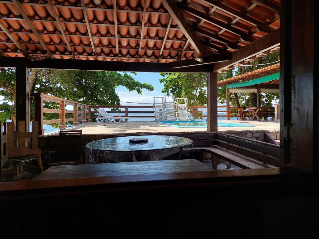 a patio with a table and a view of a pool at Espaço Villa Ará in Praia de Araçatiba