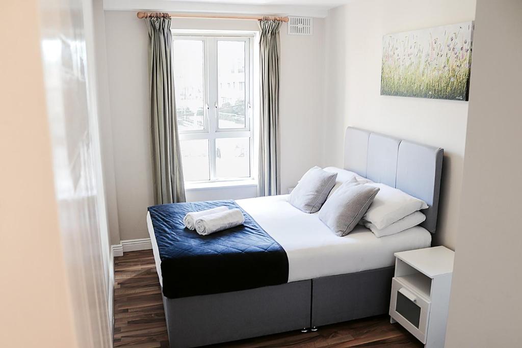 a small bedroom with a bed with a window at Harbour Square House in Dublin