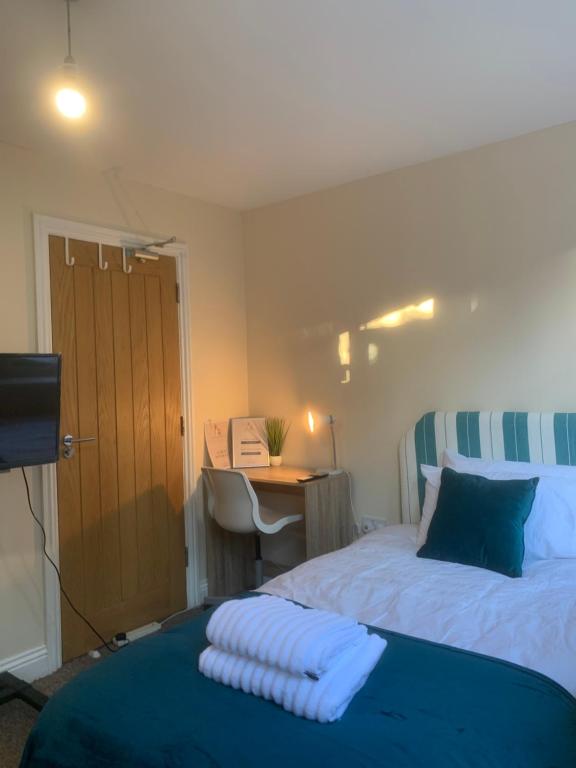 a bedroom with a bed and a desk with a desk at Cosy Room With Private Entrance & Ensuite in Reading
