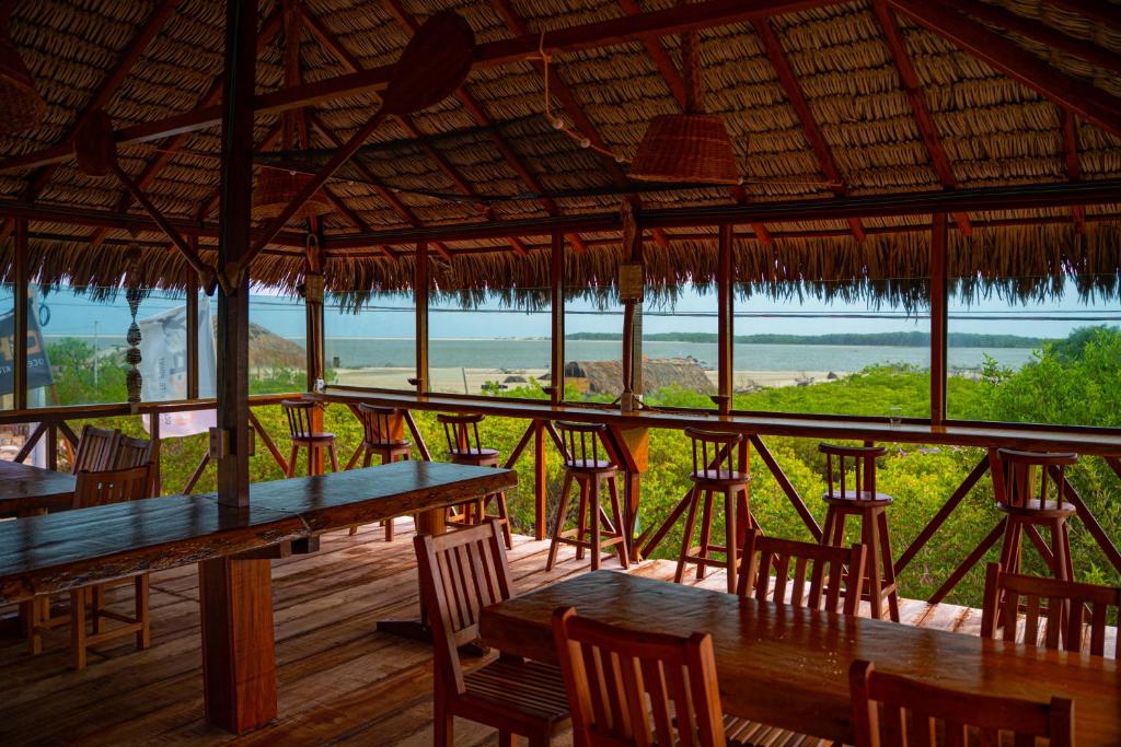 a restaurant with tables and chairs and a view of the ocean at Paraíso dos Ventos in Atins