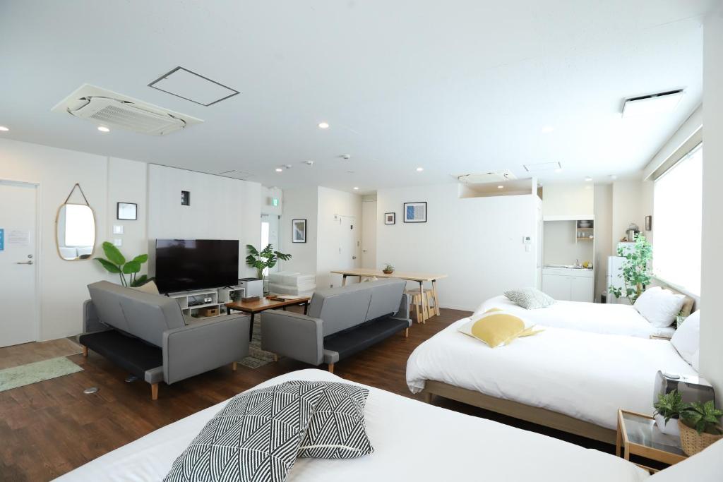 uma sala de estar com duas camas e uma televisão em RIVER VILLAS HIROSHIMA em Hiroshima