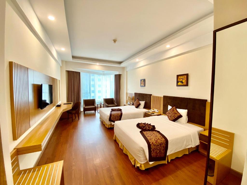 a hotel room with two beds and a television at Muong Thanh Quy Nhon Hotel in Quy Nhon